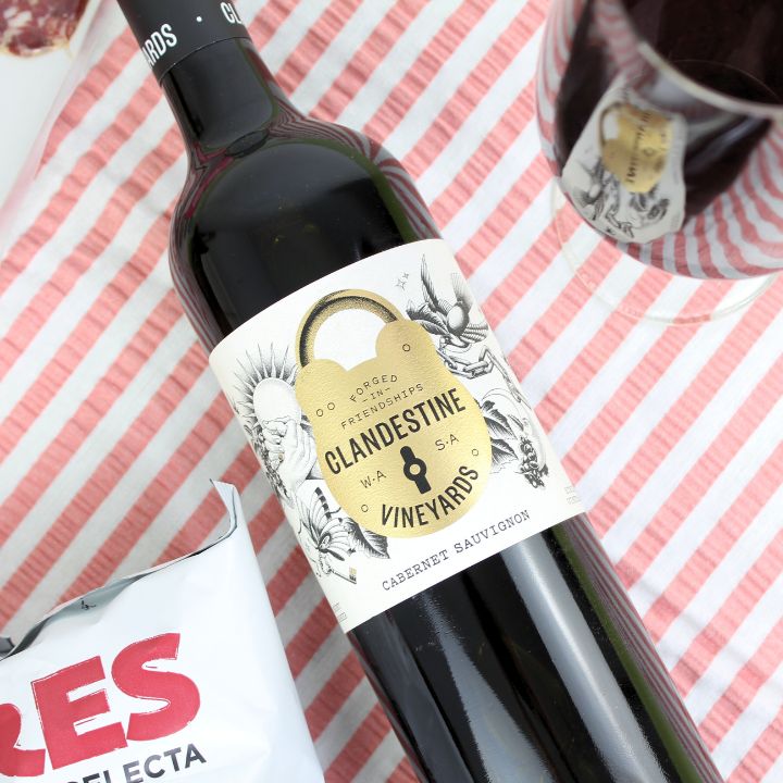 Wine bottle with &#39;Clandestine Vineyards&#39; label on a striped background