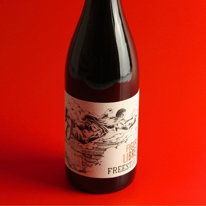 A dark glass wine bottle with a cream-colored label featuring a black illustration and the text Domaine Gayda, Figure Libre Freestyle Rouge 2024, set against a solid red background.