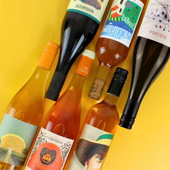 Assorted wine bottles with colorful labels on a yellow background