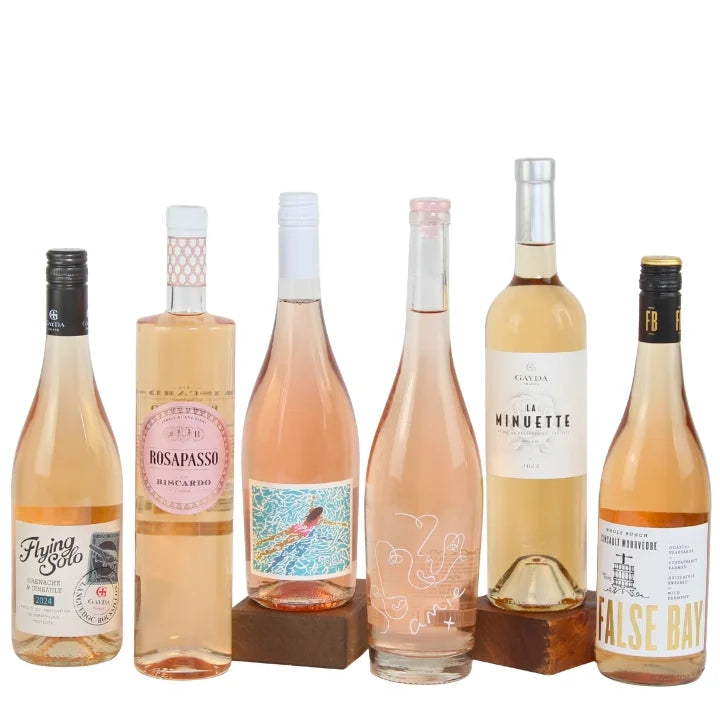 Collection of six bottles of rosé wine with various labels on a white background