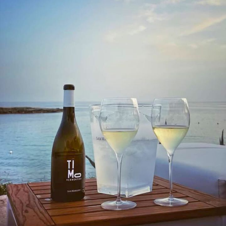 Bottle of Timo wine with two glasses by a waterfront