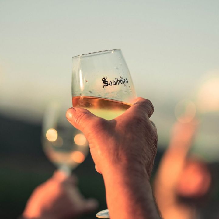 Soalheiro white wine branded glass held to the sky