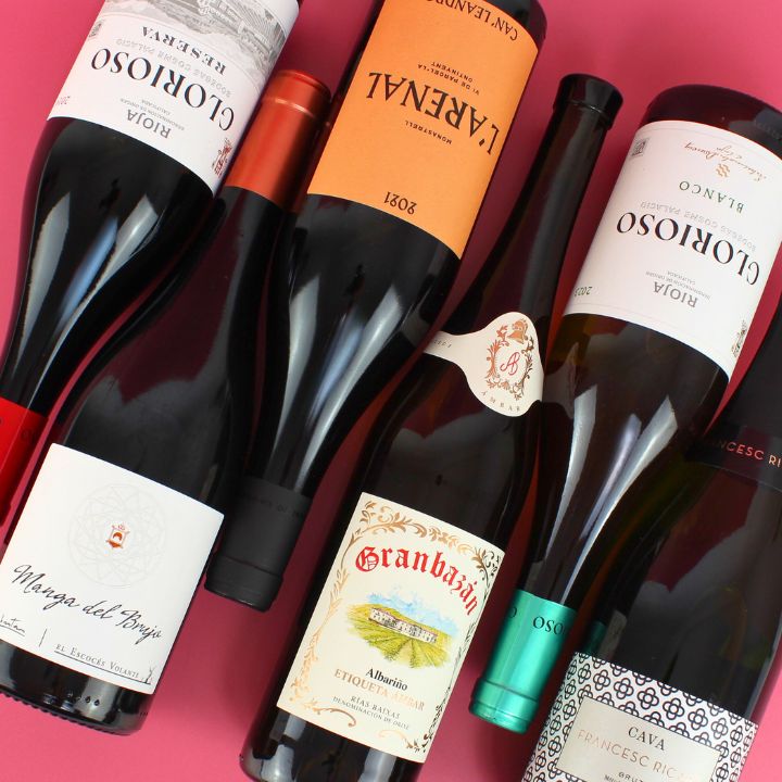 Collection of wine bottles with various labels on a pink background