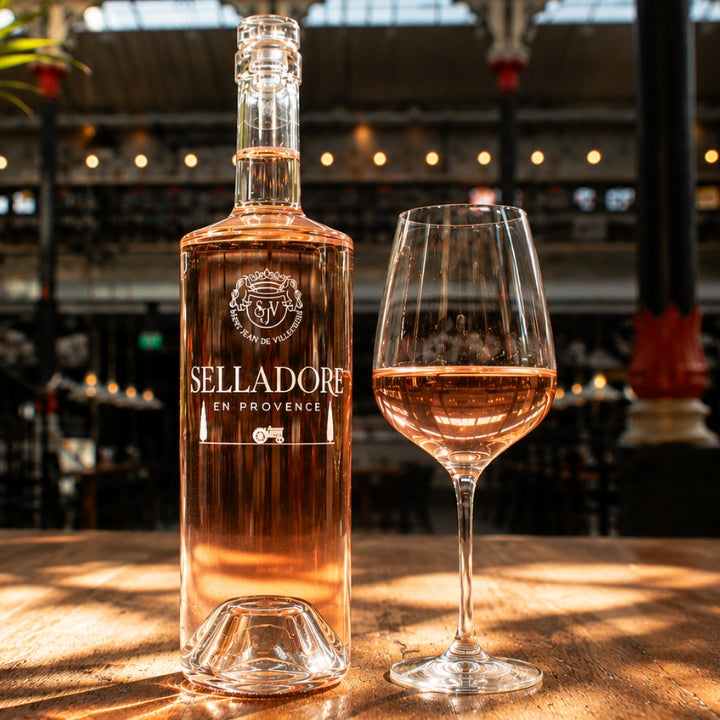 Bottle and glass of Selladore rose wine on a wooden surface with blurred background